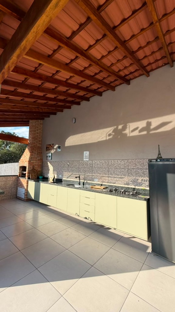 Área gourmet coberta com cozinha e telhado de madeira no Espaço Canto dos Pássaros